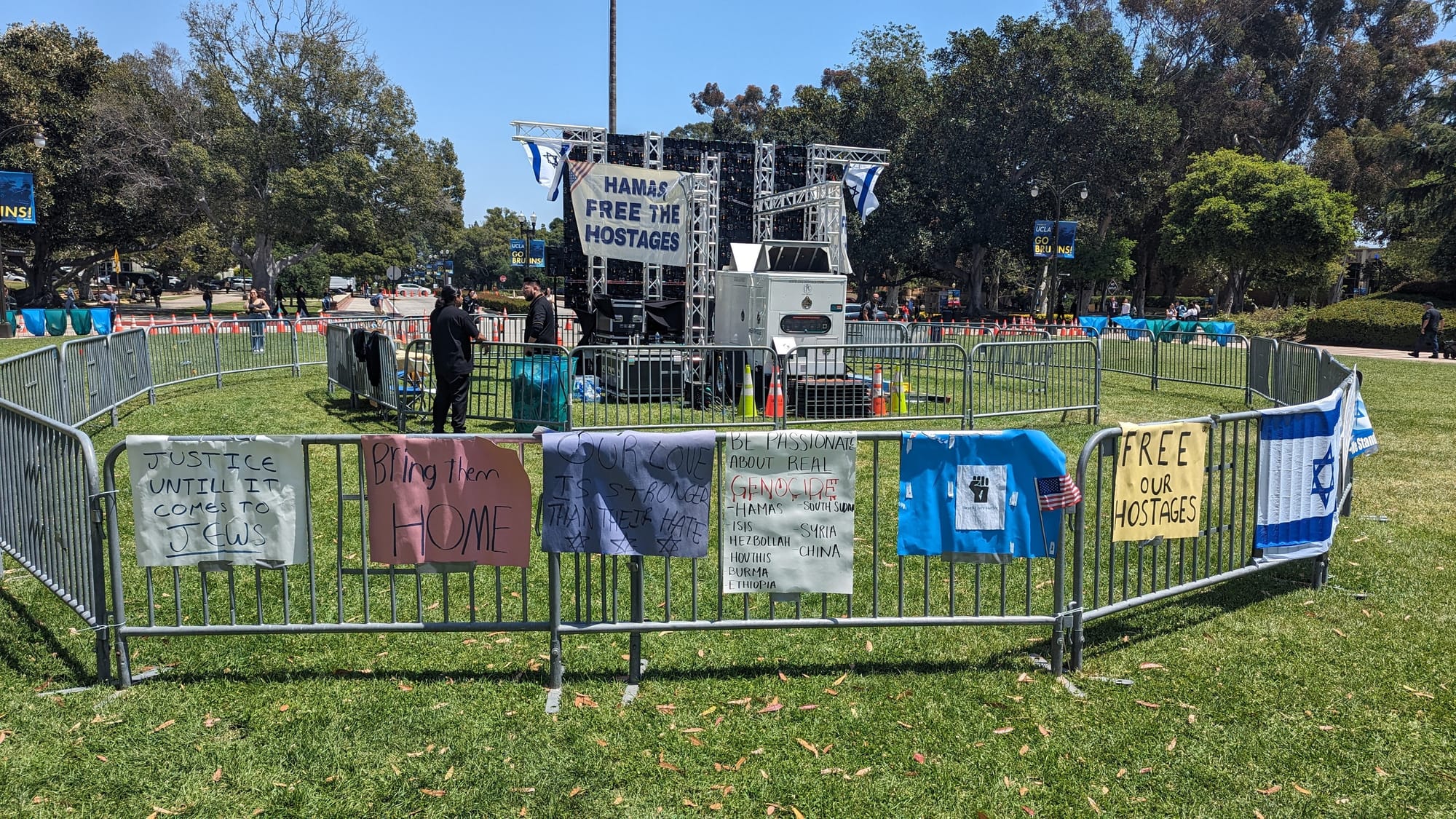 Large screen seen from behind, surrounded by many barriers and nobody around 