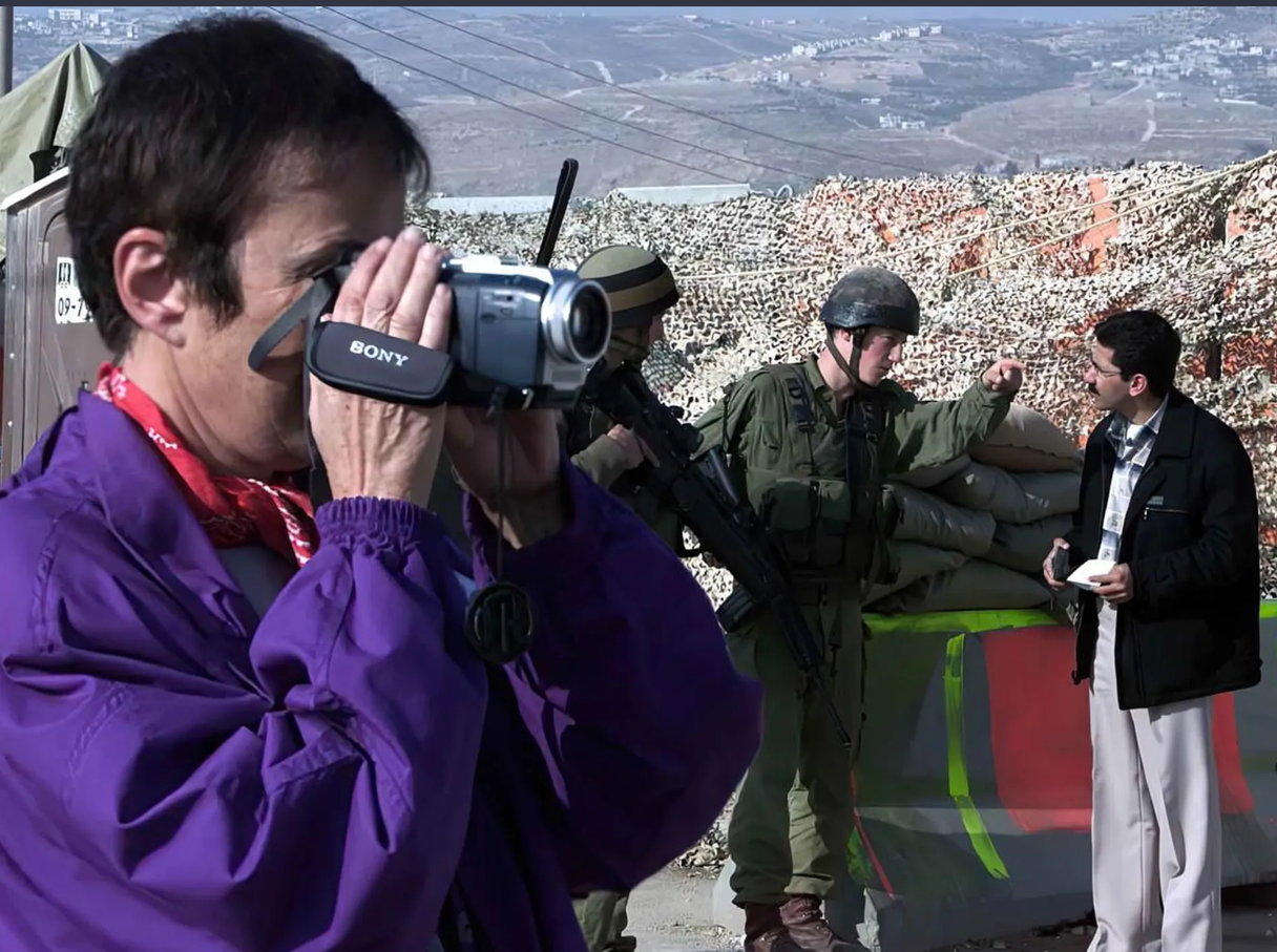 An Israeli woman films soldiers at a military checkpoint.